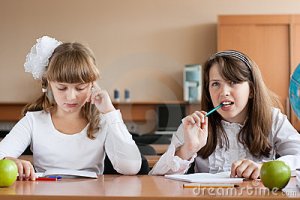 two-girls-sitting-school-desk-10627937